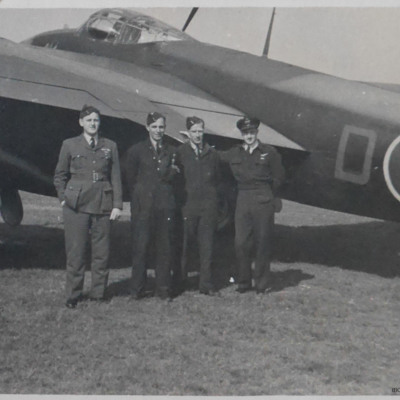 Four airmen standing next to a Mosquito. 